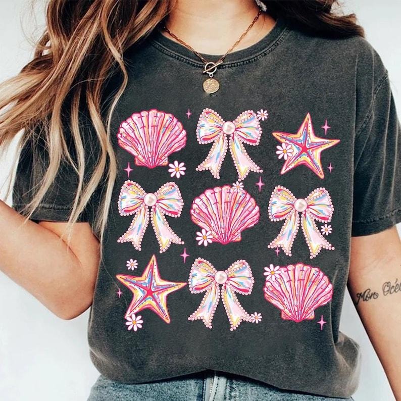 [Sale up To 43%] Comfort Colors Coquette Pearl Bow Shirt, Summer Vibes, Pink Clam Shirt, Summer Beach Shirt Comfortable Fitted